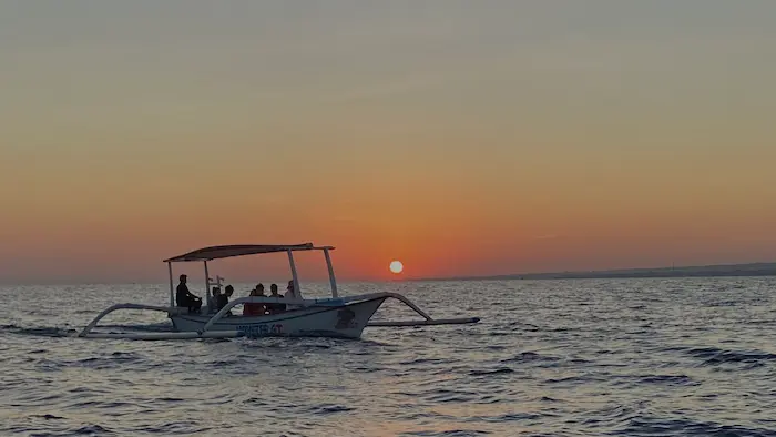 A traditional Balinese outrigger boat carrying tourists to watch the beautiful sunrise at sea in Lovina, Bali